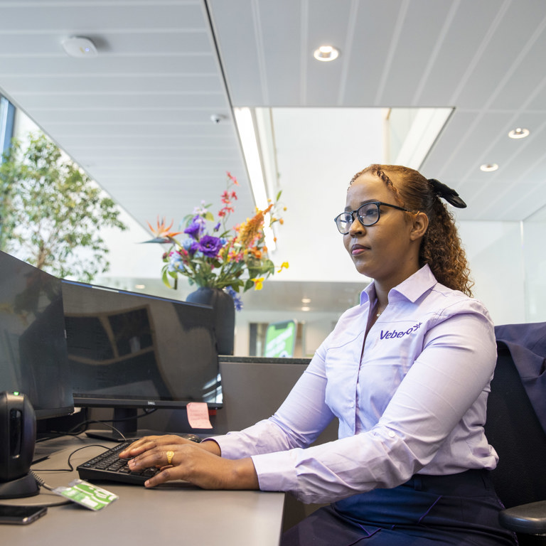 Een persoon is werkzaam achter een bureau