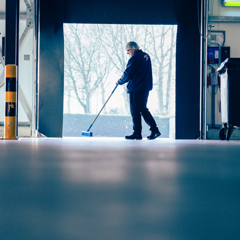 Een persoon veegt de vloer in een faciliteit in de voedingsindustrie